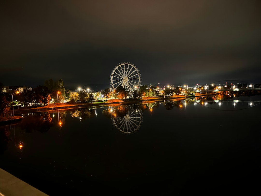 Gece ışıkları altında dönme dolap ve eğlence parkı — Fotoğraf: iRichi / Unsplash